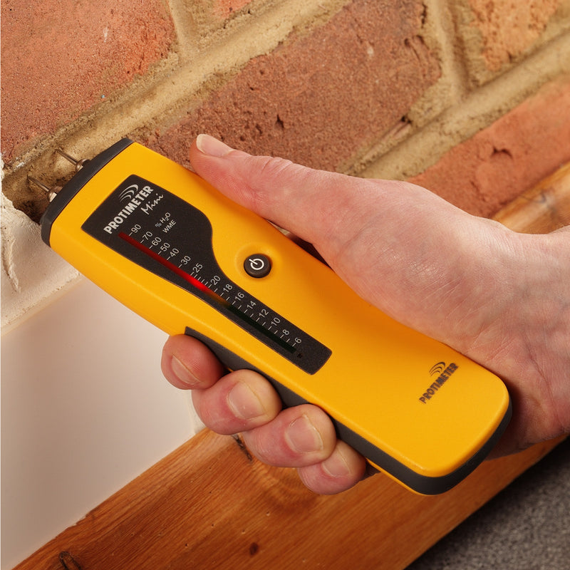 Protimeter Mini Moisture Meter being used to gauge moisture in brick